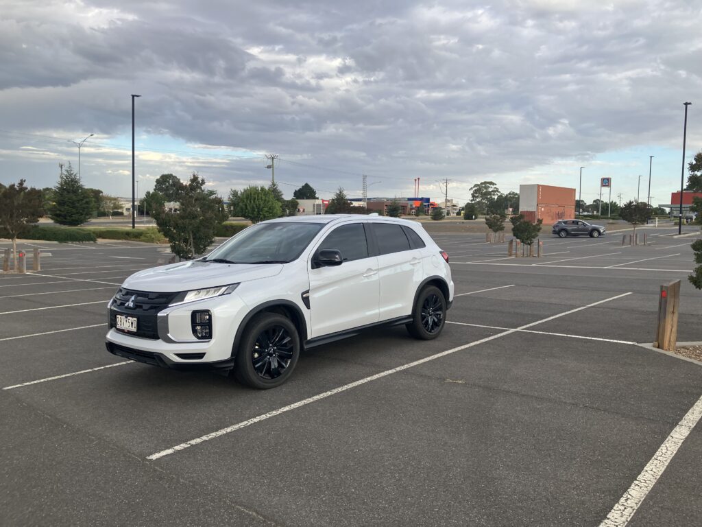 White learner driver car parked in an empty car park